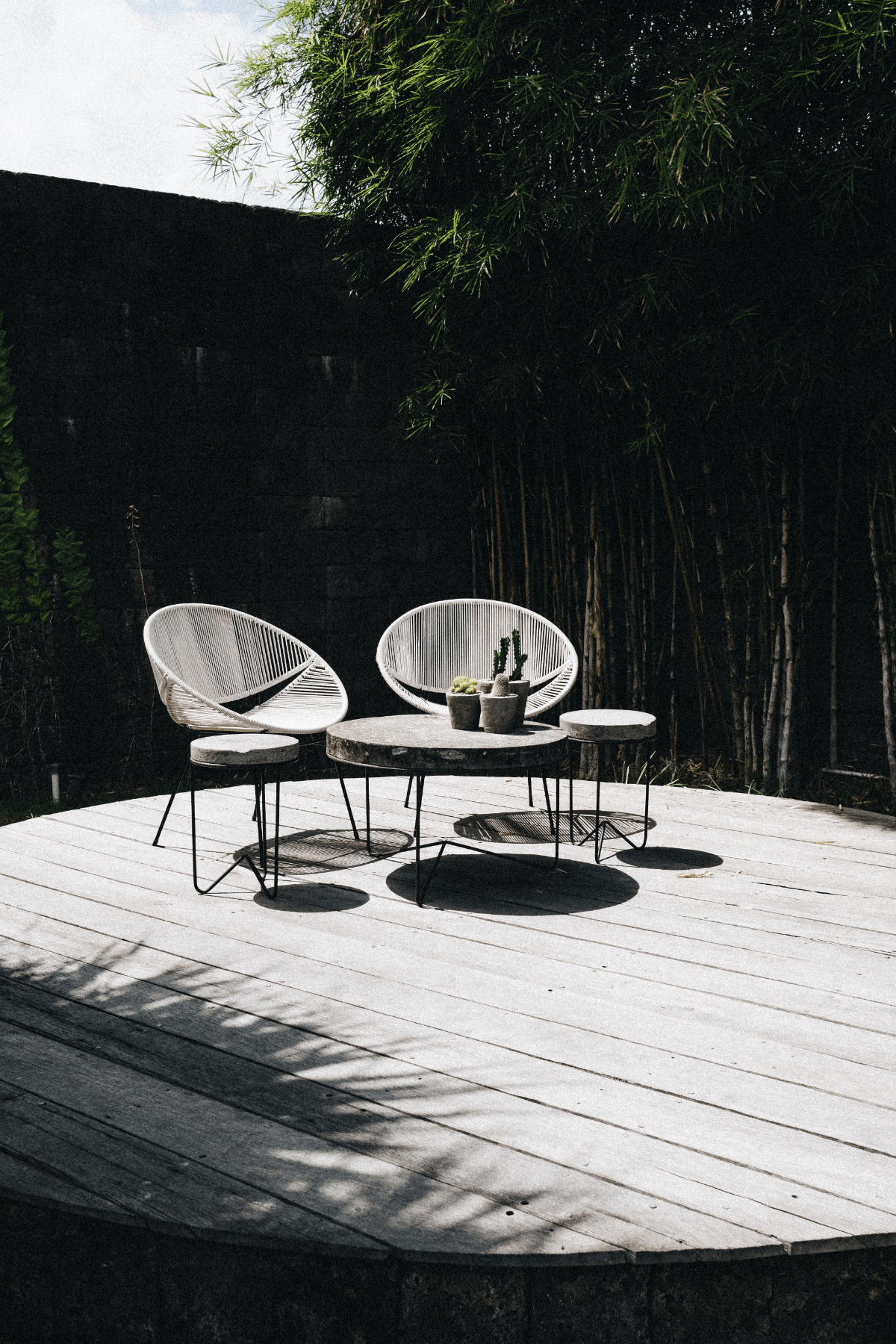 Sunlit terrace with 2 chairs and table.